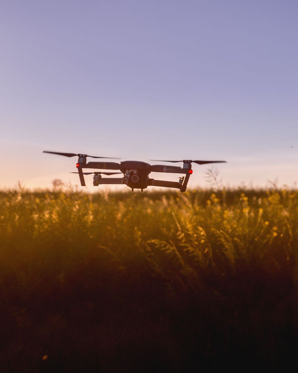 Drone in flight over a field at sunset